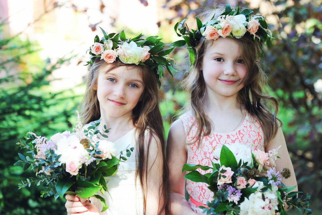 Two,beautiful,little,bridesmaids,with,flowers,outdoor